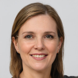 Joyful white adult female with medium  brown hair and grey eyes