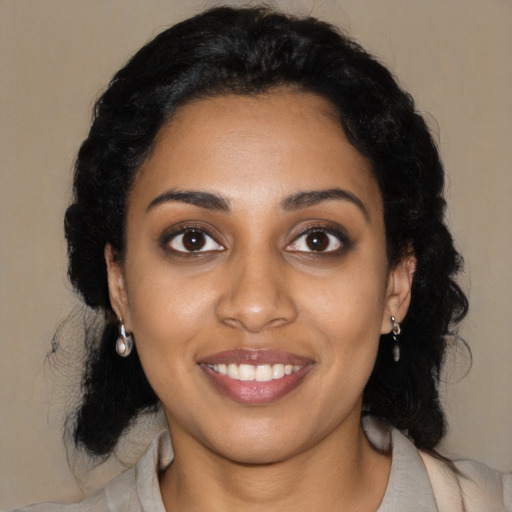 Joyful black young-adult female with long  black hair and brown eyes