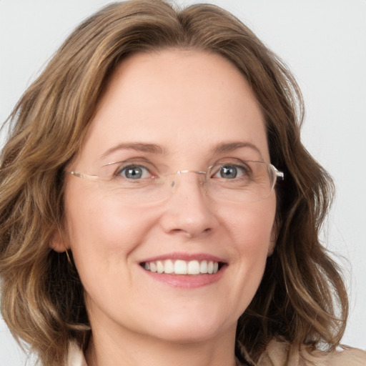 Joyful white adult female with medium  brown hair and green eyes