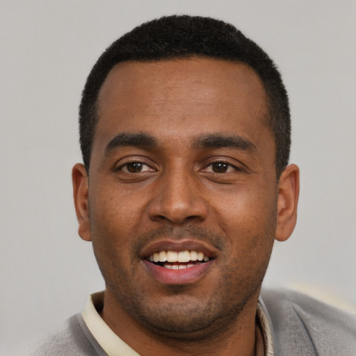 Joyful black young-adult male with short  black hair and brown eyes
