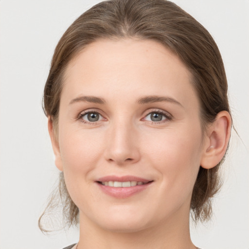 Joyful white young-adult female with medium  brown hair and grey eyes