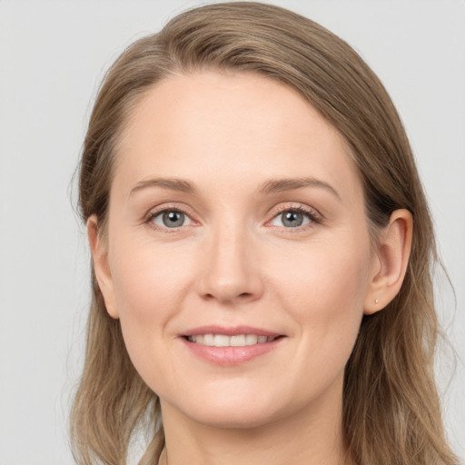 Joyful white young-adult female with long  brown hair and grey eyes