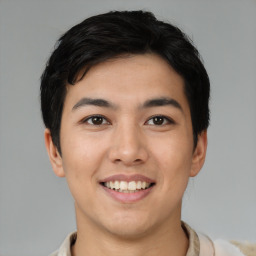 Joyful asian young-adult male with short  black hair and brown eyes