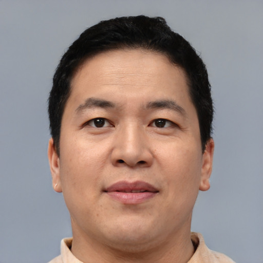 Joyful asian adult male with short  brown hair and brown eyes