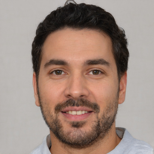 Joyful white young-adult male with short  black hair and brown eyes