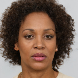 Joyful black adult female with medium  brown hair and brown eyes