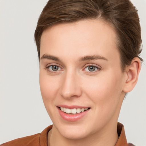 Joyful white young-adult female with short  brown hair and grey eyes