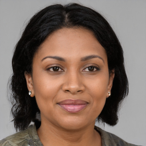 Joyful black adult female with medium  brown hair and brown eyes