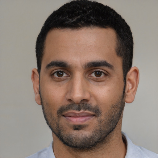 Joyful black young-adult male with short  black hair and brown eyes