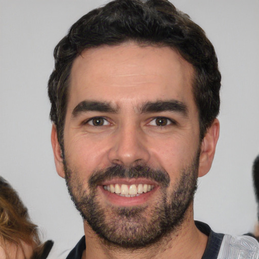 Joyful white young-adult male with short  black hair and brown eyes