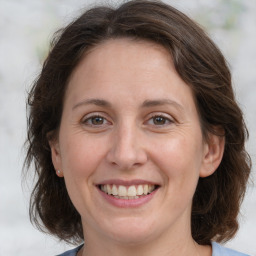 Joyful white adult female with medium  brown hair and grey eyes