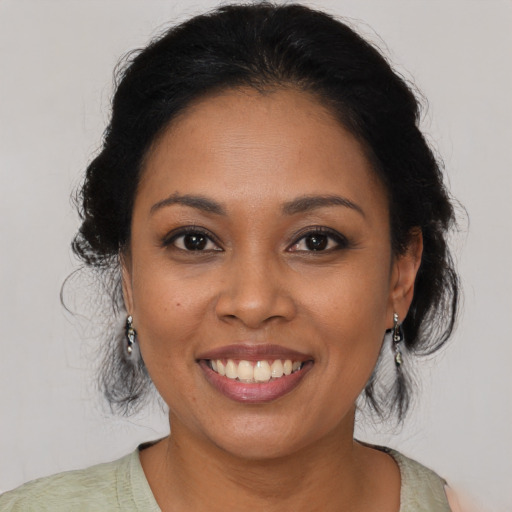 Joyful latino young-adult female with medium  brown hair and brown eyes