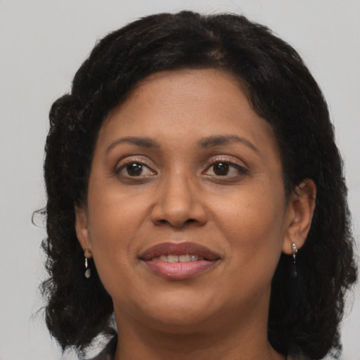 Joyful black adult female with medium  brown hair and brown eyes
