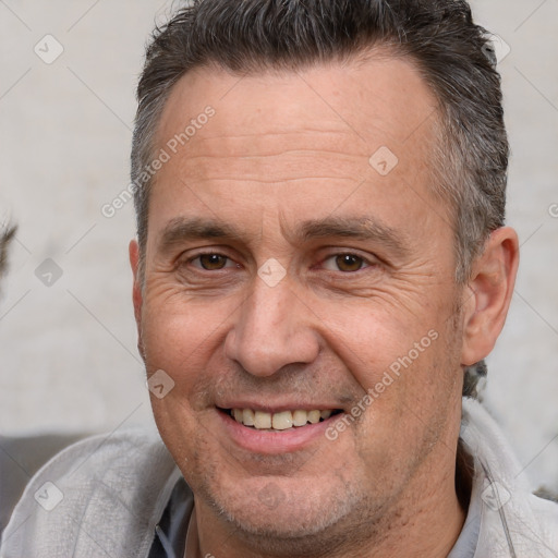 Joyful white adult male with short  brown hair and brown eyes