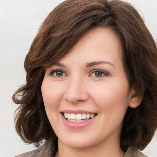 Joyful white young-adult female with long  brown hair and green eyes