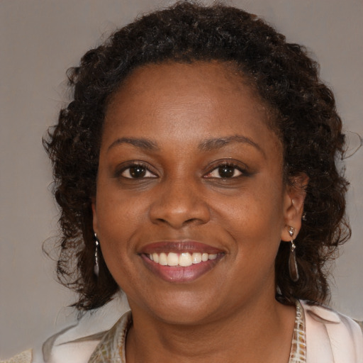 Joyful black young-adult female with medium  brown hair and brown eyes