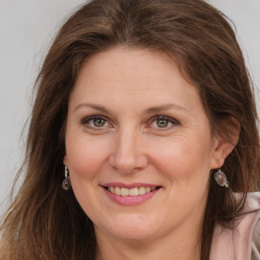 Joyful white adult female with long  brown hair and grey eyes