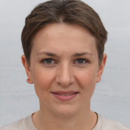 Joyful white young-adult female with short  brown hair and grey eyes