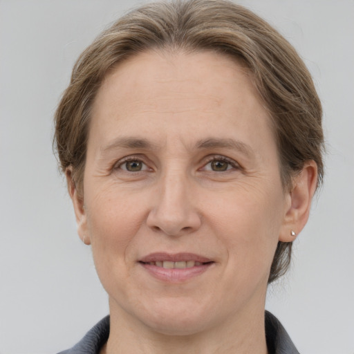 Joyful white adult female with medium  brown hair and grey eyes