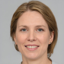 Joyful white adult female with medium  brown hair and grey eyes