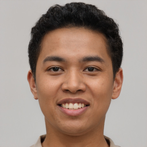 Joyful latino young-adult male with short  brown hair and brown eyes