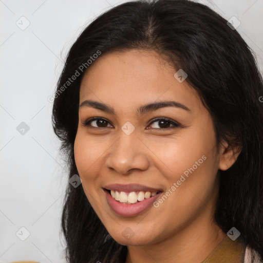 Joyful latino young-adult female with long  brown hair and brown eyes