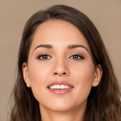 Joyful white young-adult female with long  brown hair and brown eyes