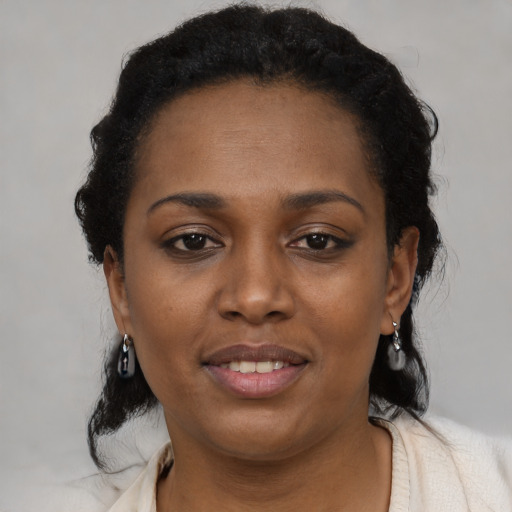 Joyful black young-adult female with medium  black hair and brown eyes