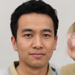 Joyful asian young-adult male with short  black hair and brown eyes