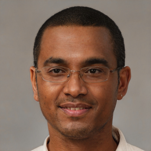 Joyful black adult male with short  black hair and brown eyes