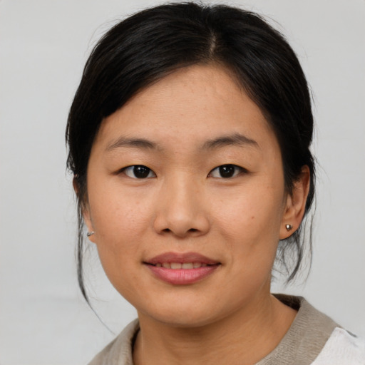 Joyful asian young-adult female with medium  brown hair and brown eyes