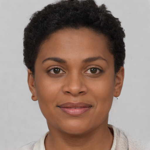 Joyful black young-adult female with short  brown hair and brown eyes