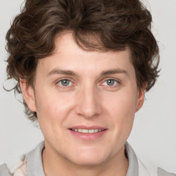 Joyful white young-adult male with medium  brown hair and grey eyes