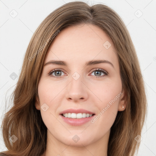 Joyful white young-adult female with long  brown hair and green eyes