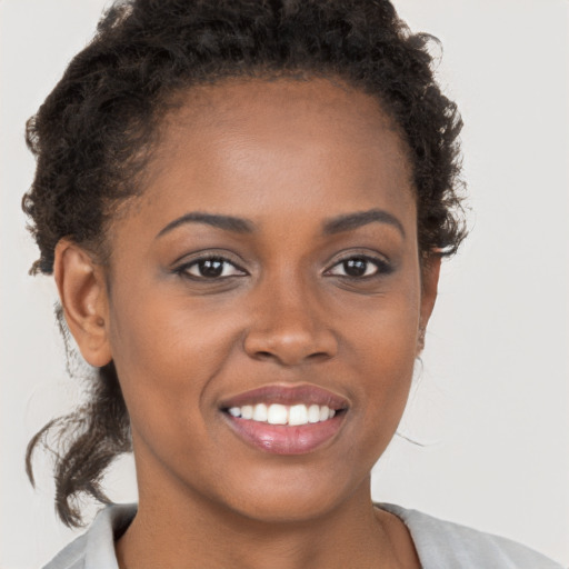 Joyful black young-adult female with short  brown hair and brown eyes