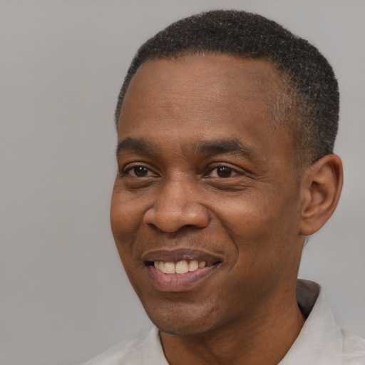 Joyful black adult male with short  black hair and brown eyes