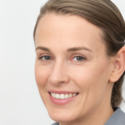 Joyful white adult female with medium  brown hair and grey eyes