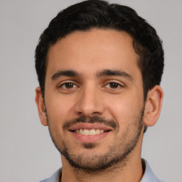 Joyful white young-adult male with short  black hair and brown eyes