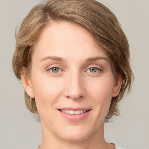 Joyful white young-adult female with medium  brown hair and blue eyes