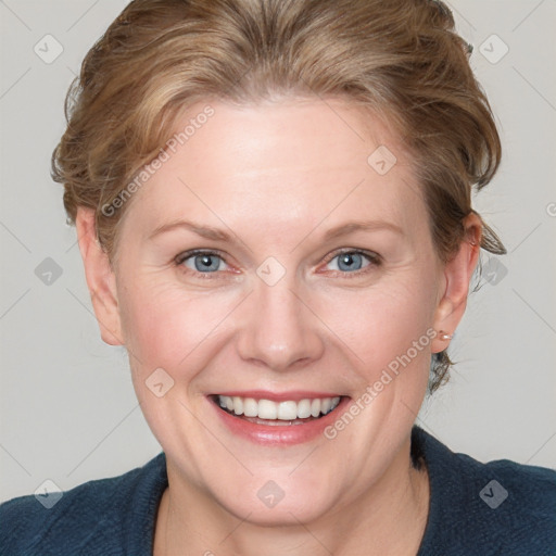 Joyful white adult female with medium  brown hair and blue eyes