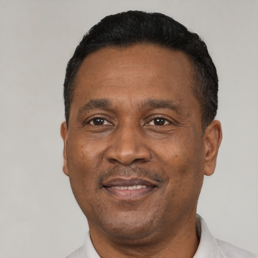 Joyful black adult male with short  black hair and brown eyes