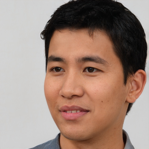 Joyful asian young-adult male with short  black hair and brown eyes