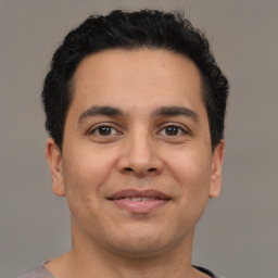 Joyful latino young-adult male with short  brown hair and brown eyes