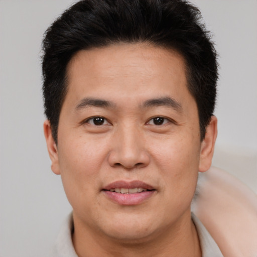 Joyful asian young-adult male with short  brown hair and brown eyes
