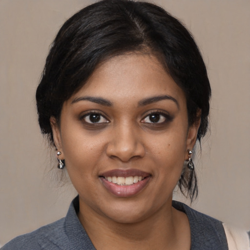 Joyful black young-adult female with medium  black hair and brown eyes