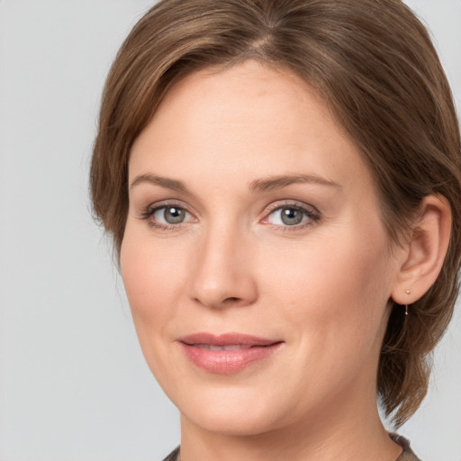 Joyful white young-adult female with medium  brown hair and grey eyes