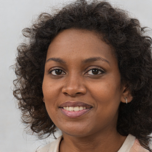 Joyful black young-adult female with medium  brown hair and brown eyes