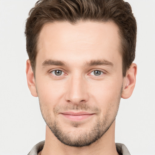 Joyful white young-adult male with short  brown hair and grey eyes