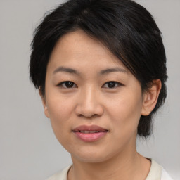 Joyful asian young-adult female with medium  brown hair and brown eyes