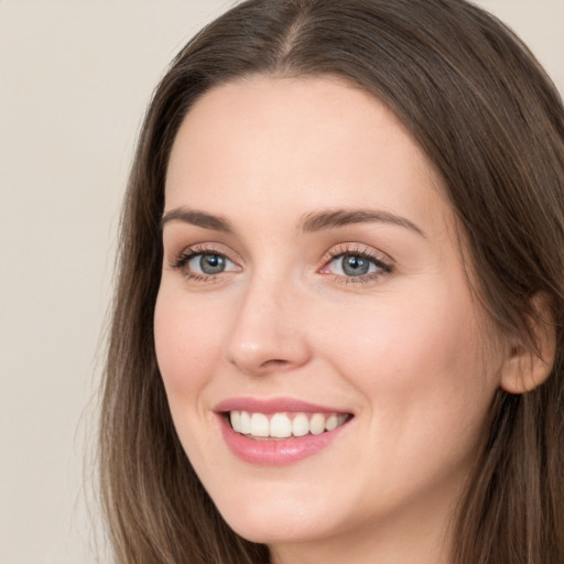 Joyful white young-adult female with long  brown hair and grey eyes